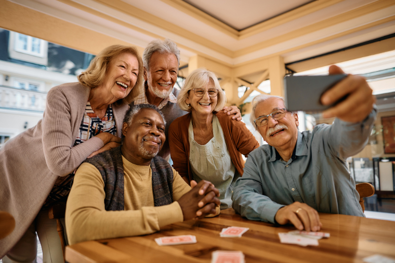 Cheerful senior having fun while taking selfie at retirement community